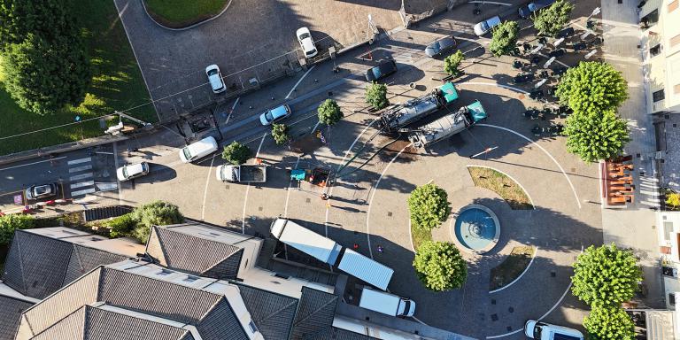 Vista aerea di una strada urbana trafficata, che mostra l’intensità del flusso veicolare e pedonale sopra le reti fognarie oggetto di riqualificazione.