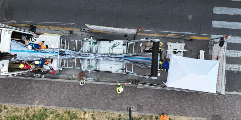 Area di cantiere con struttura mobile bianca e operatori in alta visibilità per intervento No-Dig